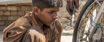 ولد صغير يعمل في تصليح الدراجات