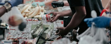 الصدقة في رمضان: فضلها وأنواعها مائدة من الطعام و رجال يوزعون الطعام