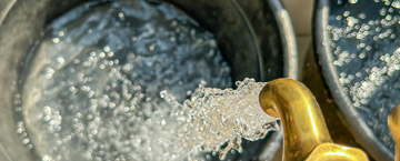 صنبور مفتوح ينزل منه ماء في الدلو